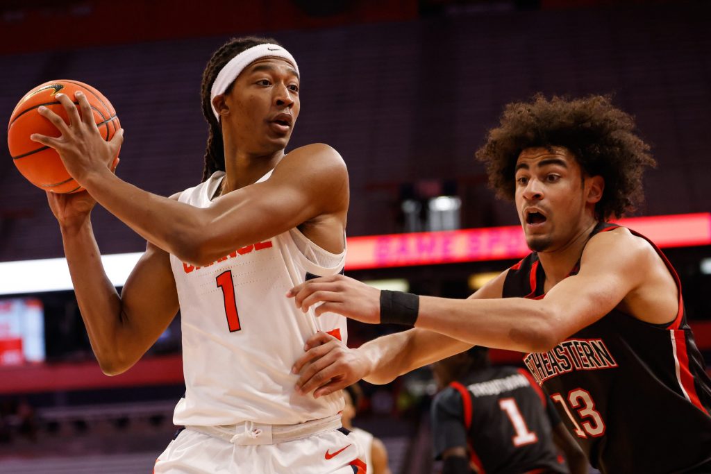 After pulling down a rebound, Syracuse's Maliq Brown (1) keeps it away from Northeastern's Jared Turner (13).