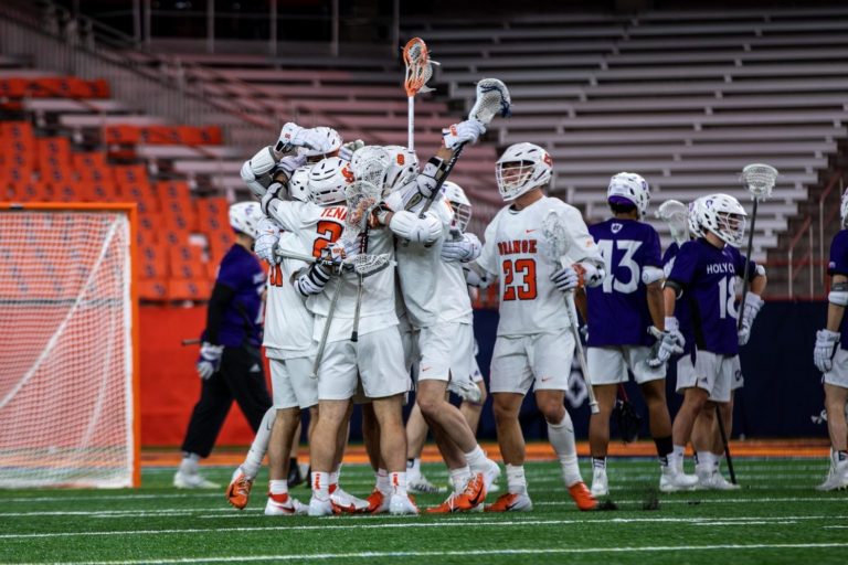 The Syracuse Men's lacrosse team celebrates after a goal against Holy Cross during the season opener at the Carrier Dome on Saturday, February 12, 2022.