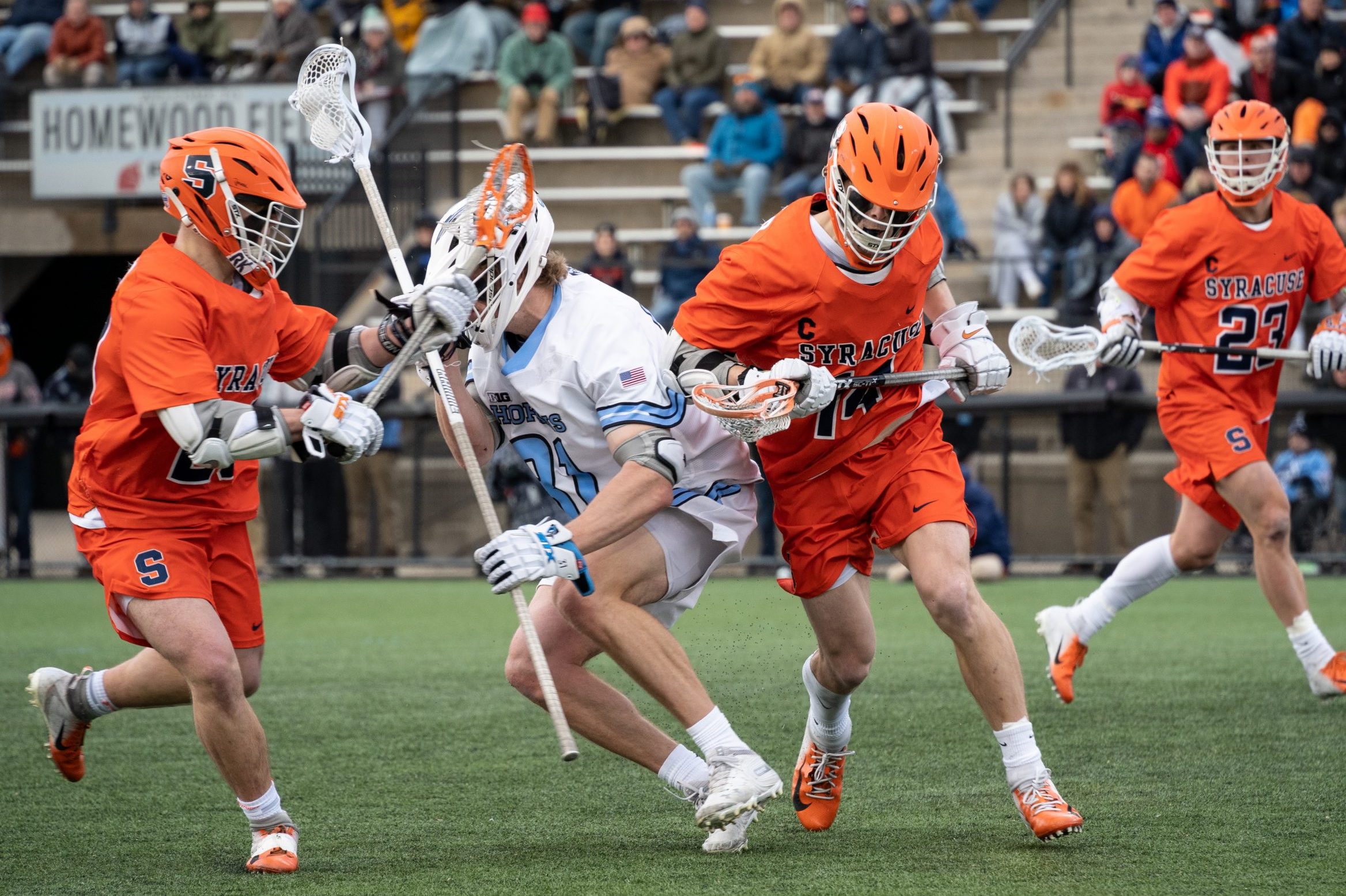Freshman Tyler Cordes and Senior Captain Owen Seebold check a Johns Hopkins defender -- SU vs. Johns Hopkins - Lacrosse - March 13, 2022 - Baltimore, Maryland