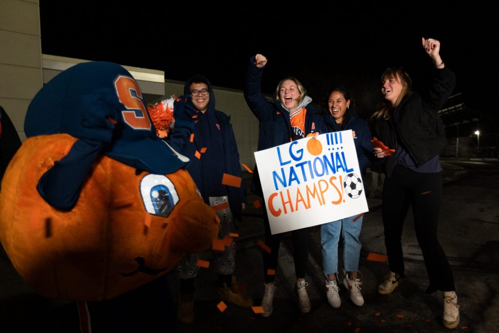 Students and fans dance with Otto the Orange at 2 a.m. before the Men’s Soccer arrival at the John A Lally Athletics Complex on December 13, 2022 in Syracuse, New York.