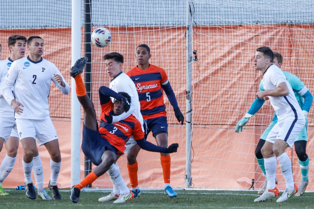 Syracuse's Abdi Salim (3) follows through on a bicycle kick as he's pulled down by Penn's Aaron Messer.