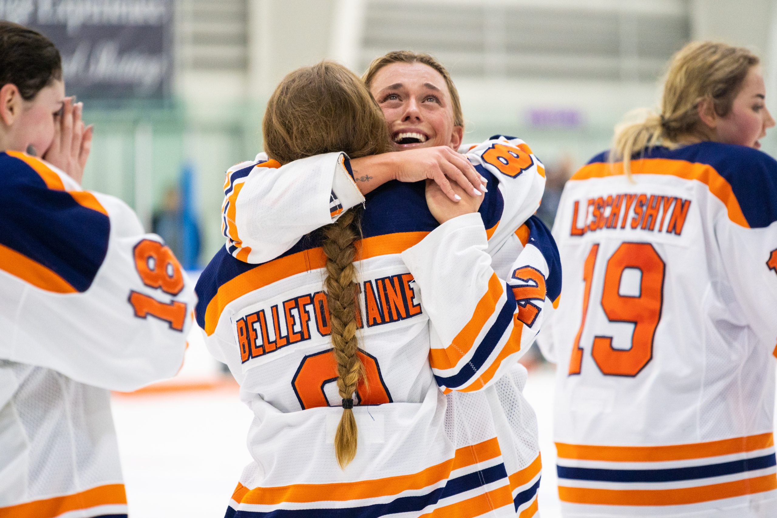 Syracuse senior Lauren Bellefontaine and graduate student Victoria Klimek hold back tears as they hug each other after winning the CHA championship in overtime.