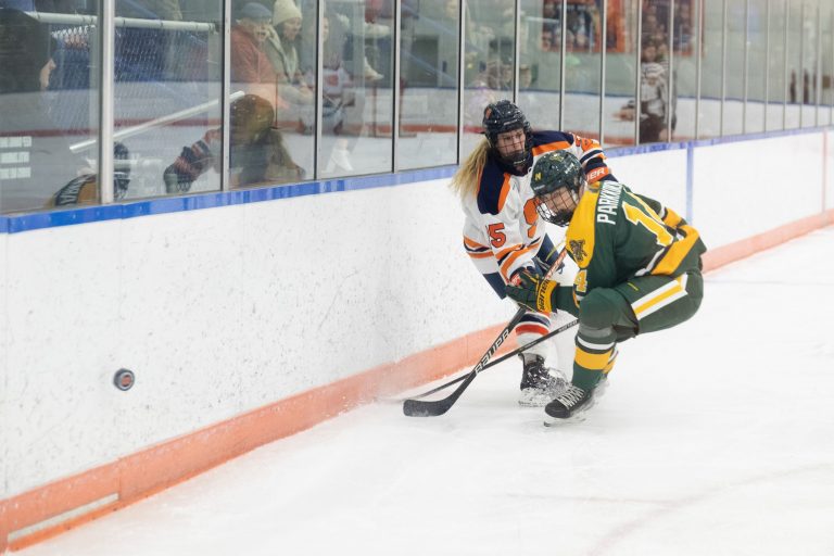 Hannah Johnson and #14, Krista Parkkonen battle for the puck during the women's Ice Hockey game on Friday, December 9, 2022 at Tennity Ice Pavilion in Syracuse, NY.