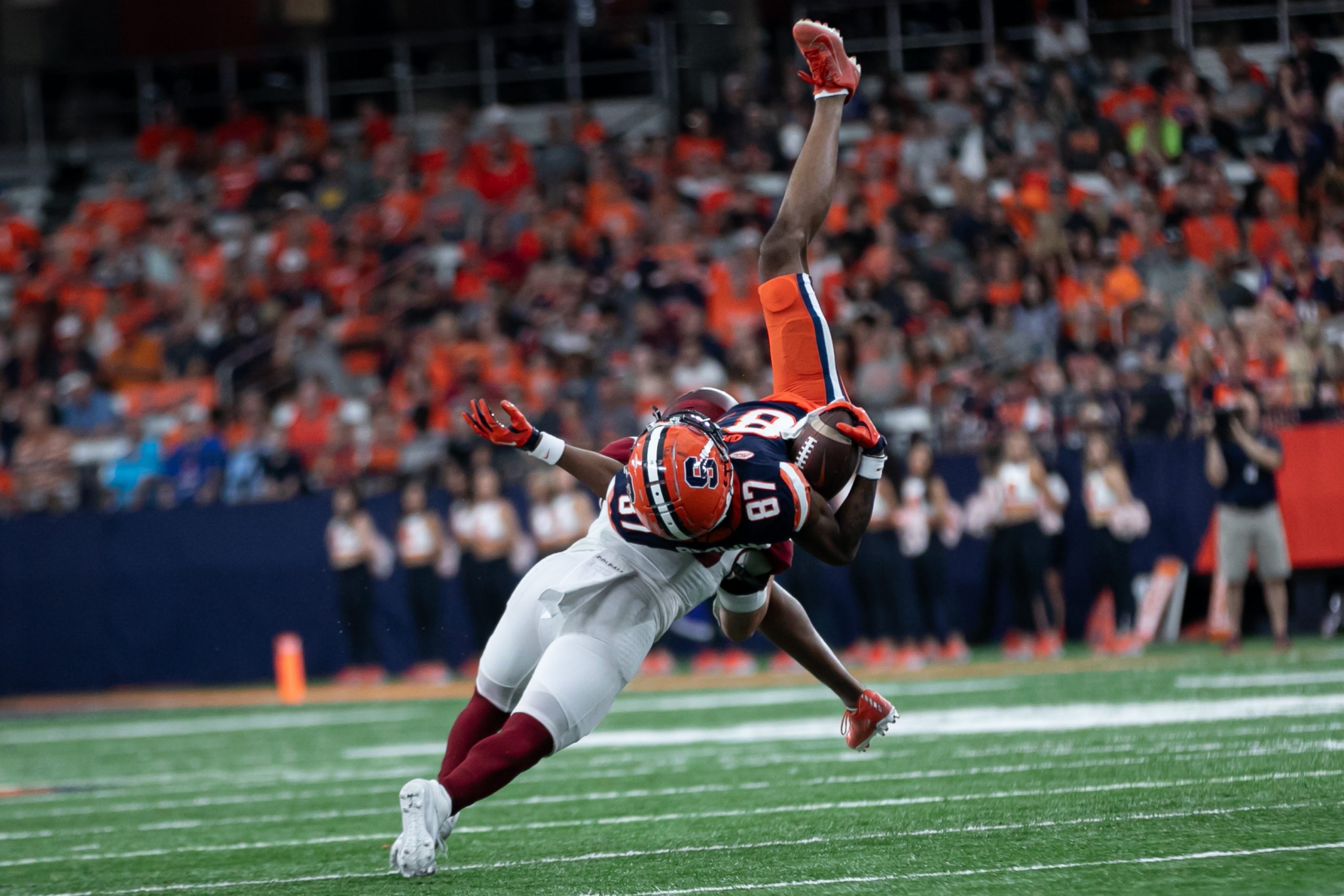 Colagte's Sage Luther (29) flips Syracuse's Donovan Brown (87) during the season opening game on September 2, 2023 at JMA Wireless Dome. Photo by Kayla Breen.