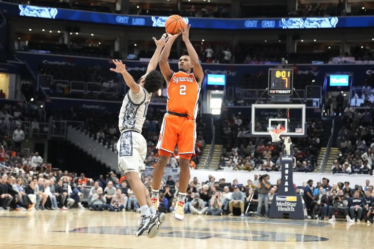 J Starling #2 of the Syracuse Orange takes a jump over Jayden Epps #10 of the Georgetown Hoyas in the second half during a college basketball game against the Georgetown Hoyas at the Capital One Arena on December 9, 2023 in Washington, DC.