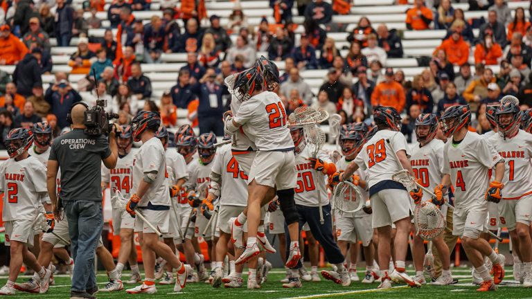 The Syracuse men's lacrosse team celebrates after a season-opening win against Vermont Saturday at JMA Wireless Dome.