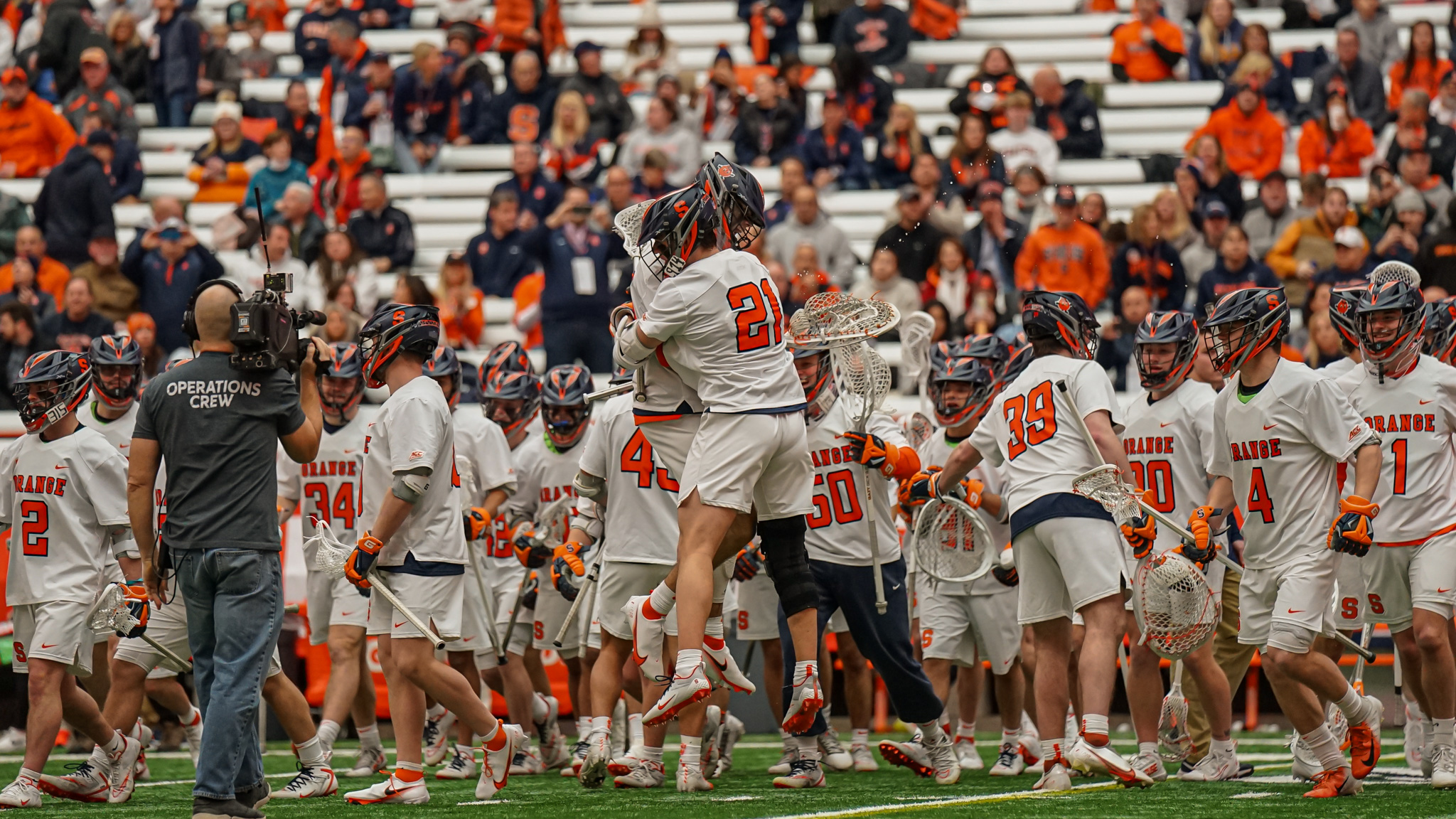 The Syracuse men's lacrosse team celebrates after a season-opening win against Vermont Saturday at JMA Wireless Dome.