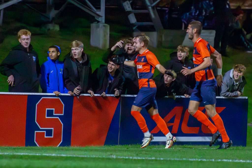 Midfielder Felipe D'Agostini (#11) celebrates with fans and teammate Pablo Pedregosa (#2) after a goal.