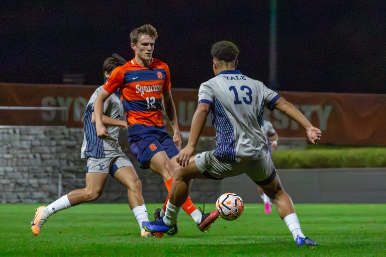 Syracuse defender Gavin Wigg (#12) passes the ball between Yale's defenders on Wednesday.