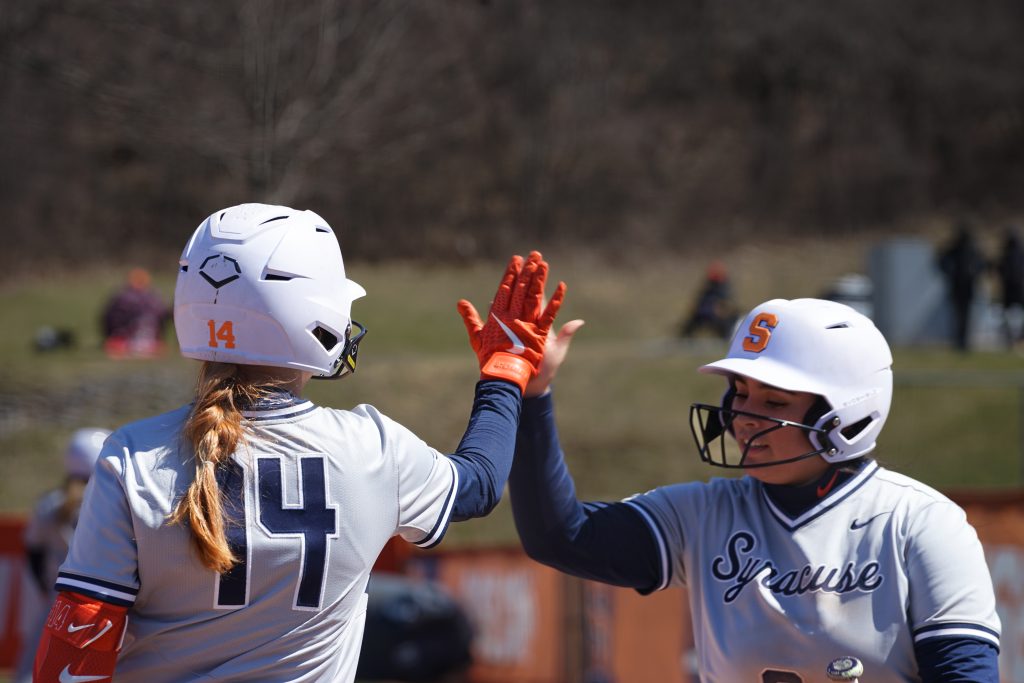 Syracuse players Kelly Breen (14) and Madelyn Lopez high-five after a run.