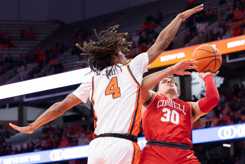 Cornell's Chris Manon (#30) goes up for a shot against Syracuse's Chris Bell (#4) during Tuesday's game.