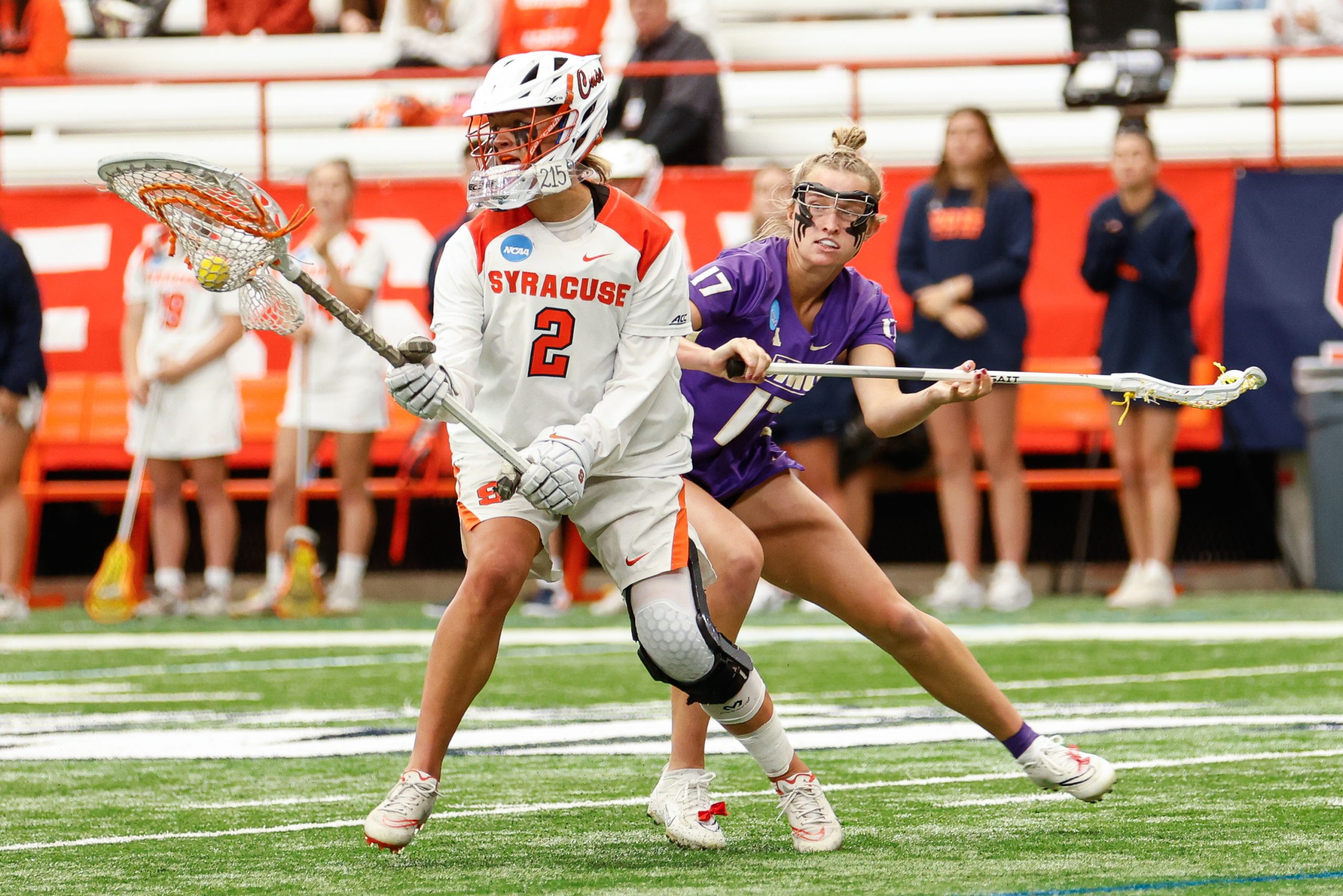 Syracuse goalkeeper Delaney Sweitzer (2) looks for an open teammate as James Madison's Isabella Peterson (17) tries to block during the NCAA Tournament quarterfinal on Thursday, May 18, 2023 at JMA Wireless Dome. Photo by Kayla Breen.