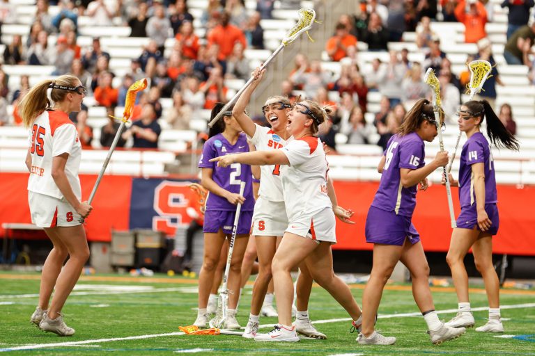 Syracuse's Natalie Smith (15), Olivia Adamson (1) and Savannah Sweitzer (35) celebrate a goal during the NCAA Tournament quarterfinal on Thursday, May 18, 2023 at JMA Wireless Dome. Photo by Kayla Breen.