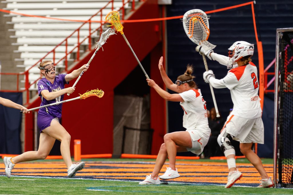 Syracuse goalkeeper Delaney Sweitzer (2) stops a ball launched by James Madison's Katelyn Morgan (11) during the NCAA Tournament quarterfinal on Thursday, May 18, 2023 at JMA Wireless Dome. Photo by Kayla Breen.