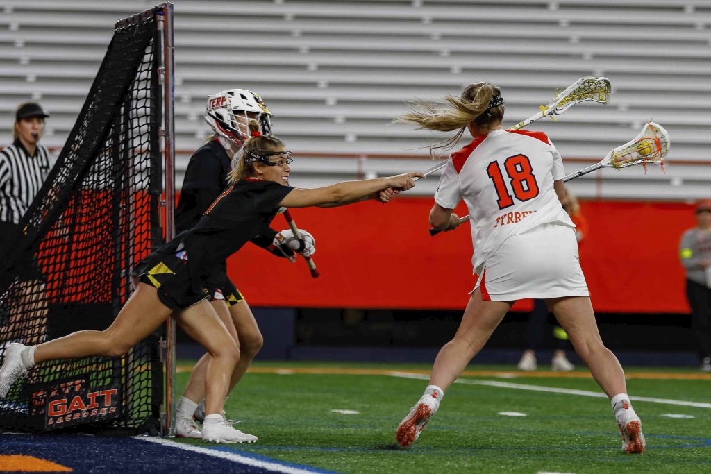 Meaghan Tyrrell (18) scores a goal for Syracuse against Maryland goalkeeper Emily Sterling (33).