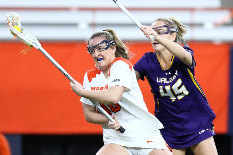 Meaghan Tyrrell #18 of Syracuse Orange moves the ball against Mackenzie Beam #45 of Albany Great Danes during a women’s lacrosse game at JMA Wireless Dome on March 1, 2023.