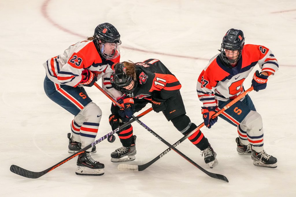 Forwards Marielle McHale (#23) and Heidi Knoll (#27) wrestle the puck away from their RIT opponent on Saturday, February 10.