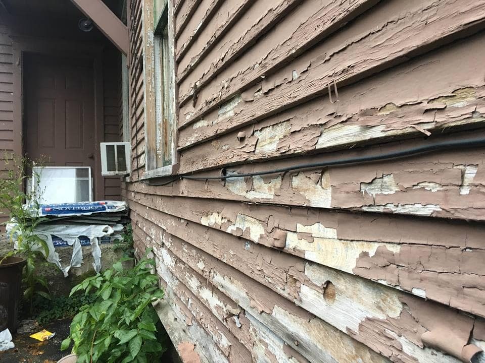Lead paint peeling off a Syracuse house, posing a potential risk of lead poisoning