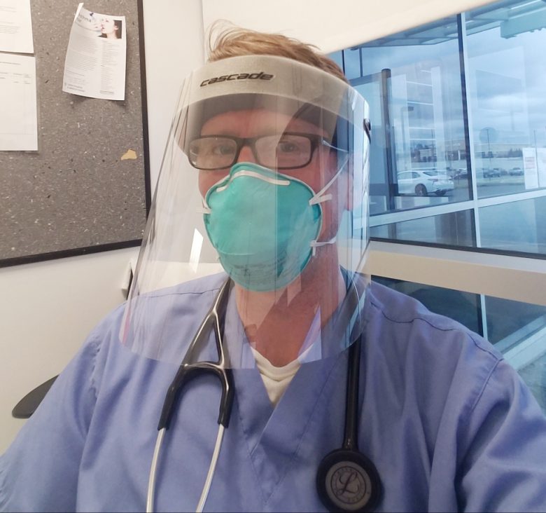 Brendan Johnston, an emergency department nurse practitioner, wears a face mask produced by Cascade lacrosse manufacturers in Liverpool, New York.