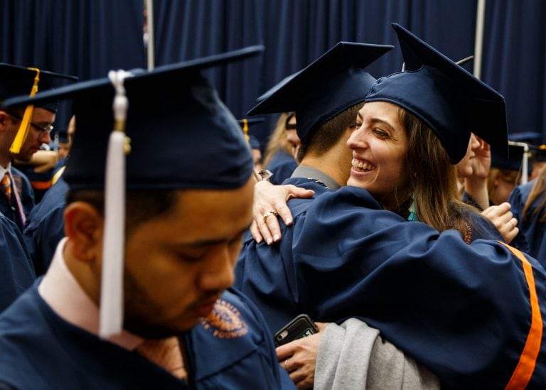 Students embrace each other before walking to their seats.