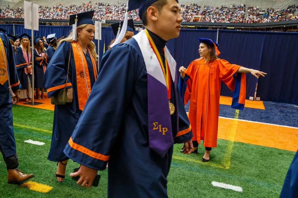 Anxiously waiting for their big moment, graduates watch as other students get their chance to walk out at commencement.