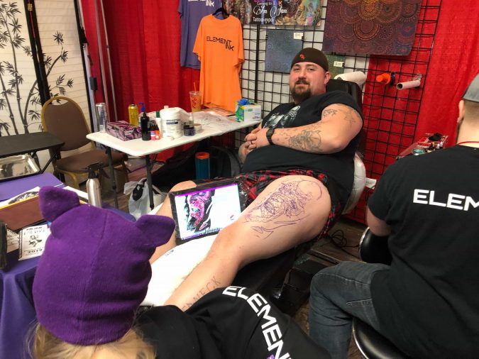 Jeffrey Miner sits in chair while getting a tattoo at the Am-Jam Tattoo Expo