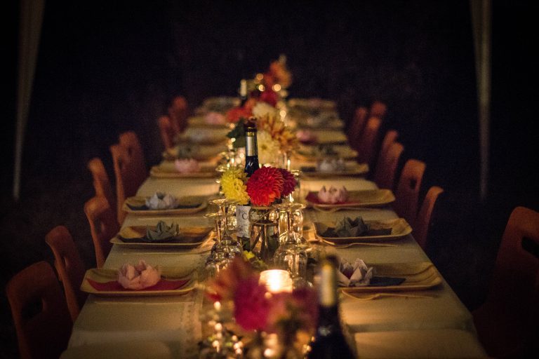 A holiday dinner table setting featuring wine bottles