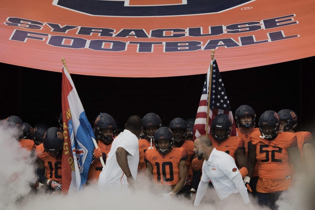 Head coach Dino Babers (left in white shirt) and his Orange football team prepares to run onto the Carrier Dome field prior to the Syracuse-Connecticut football game on Sept. 22, 2018