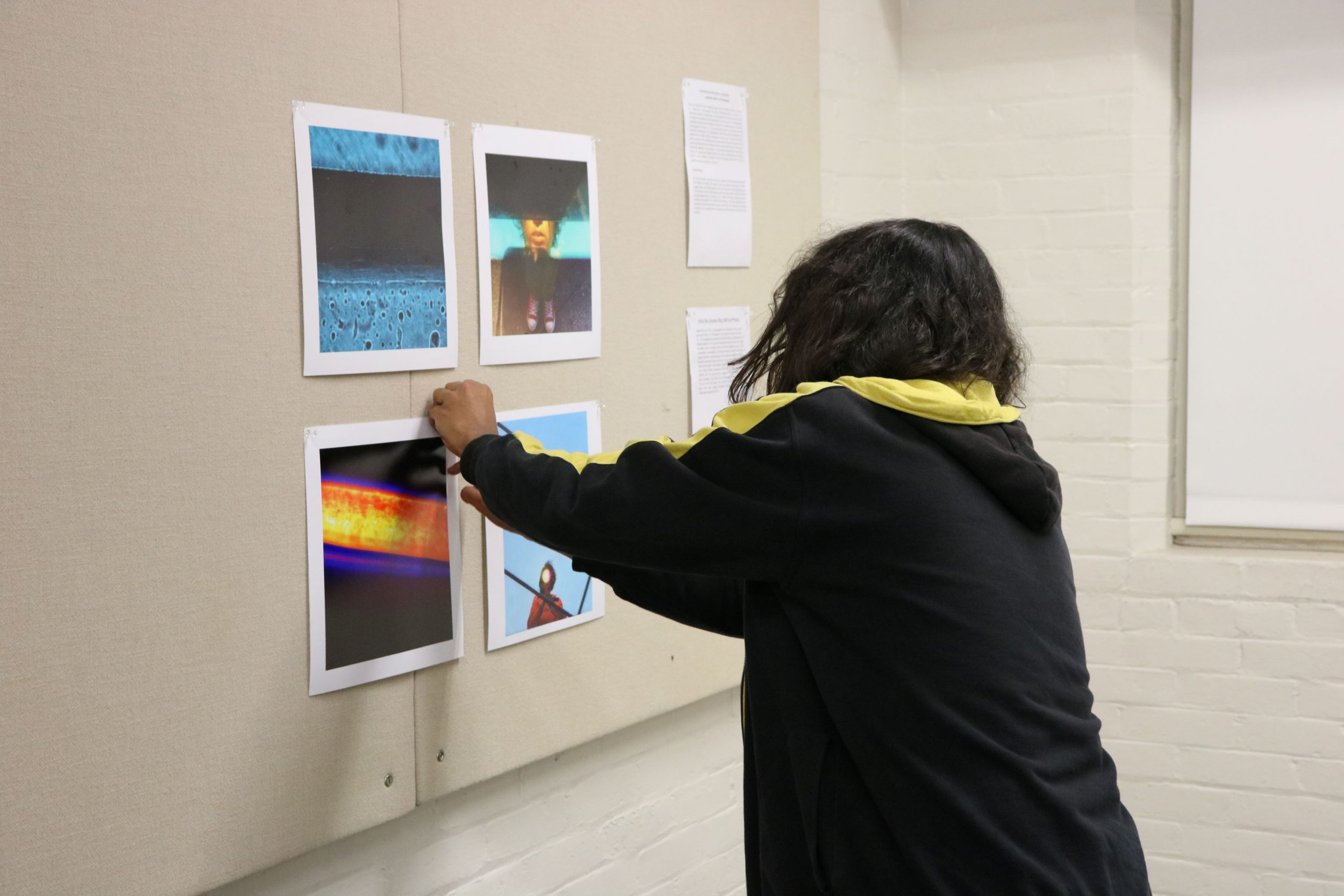 Anshul Roy hangs up pieces in his study at Smith Hall.