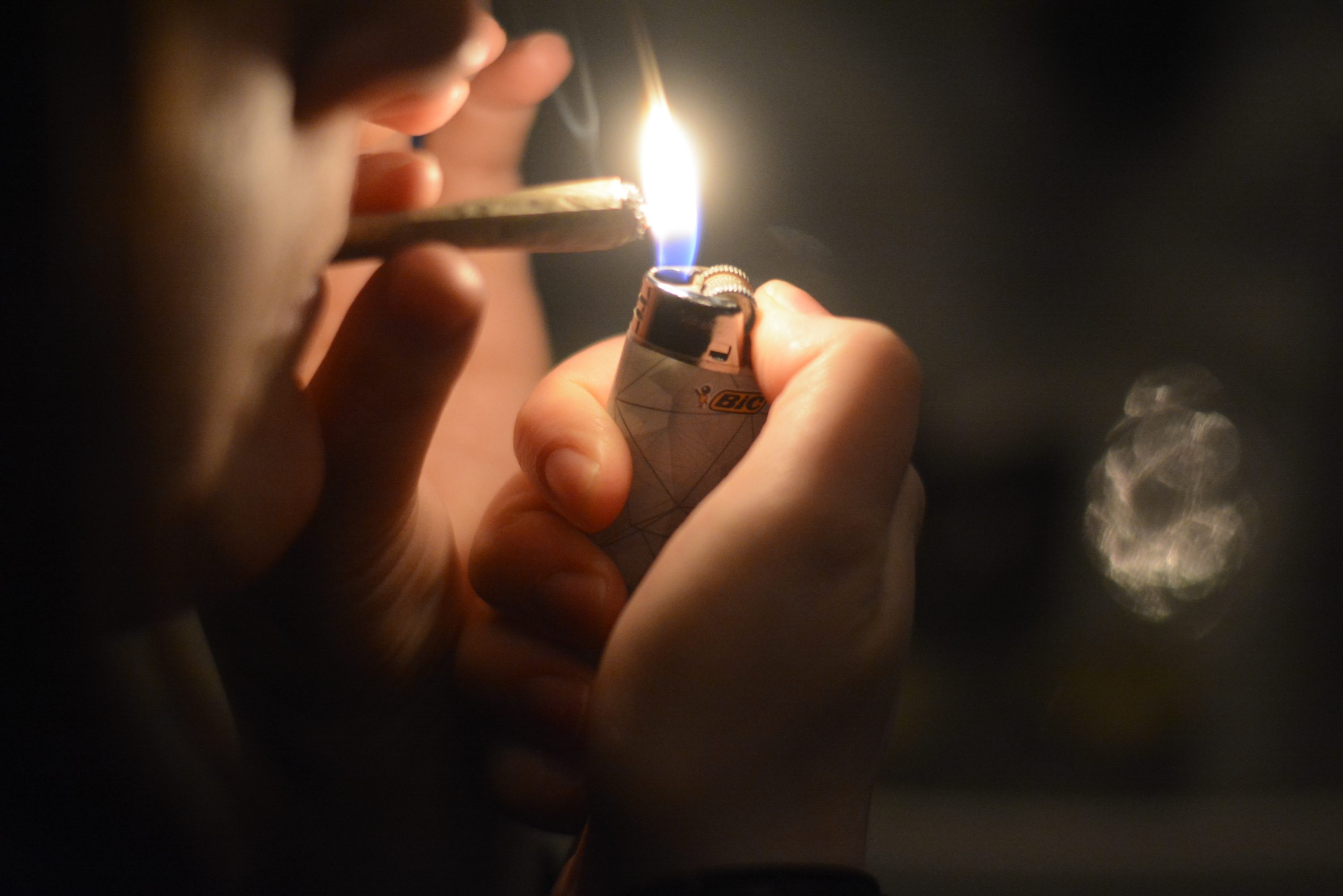 A Syracuse student lights a marijuana cigarette in their apartment.