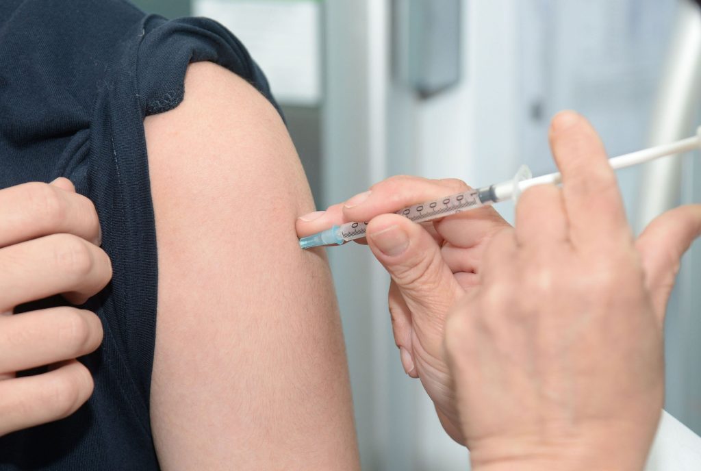 Flu Shot given into person's arm - Stock Image