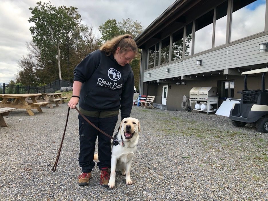 Kellie Hatton, a trainer at Clear Path for Veterans, with Bolden, an English Labrador who's in training