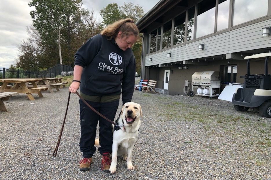 Kellie Hatton, a trainer at Clear Path for Veterans, with Bolden, an English Labrador who's in training