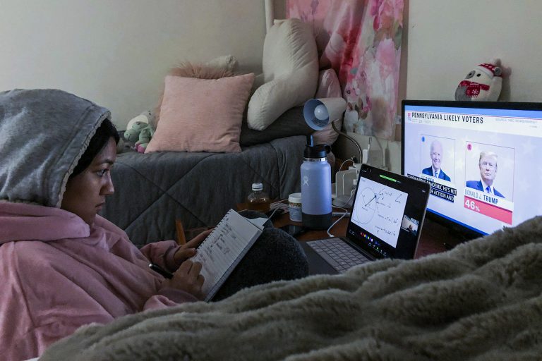 Bella Lamothe, quarantined in the Alpha Chi Omega house, watches Election Day coverage as she takes notes for class.