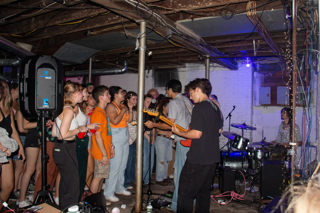 Performer and crowd of students together during a show at Mudpit concert venue